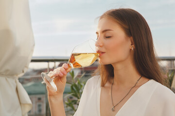 Close up of a beautiful happy woman enjoying drinking wine outdoors