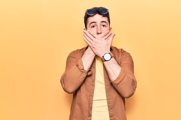Obraz premium Young hispanic man wearing casual clothes shocked covering mouth with hands for mistake. secret concept.