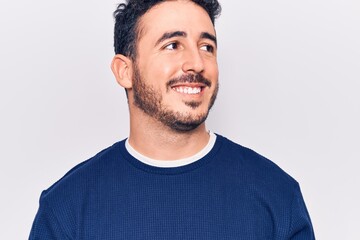 Obraz premium Young hispanic man wearing casual clothes looking to side, relax profile pose with natural face and confident smile.