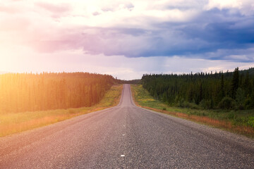 Beautiful View of a scenic road, Alaska Highway, in the Northern Rockies during a sunny and cloudy morning sunrise. Taken in British Columbia, Canada. Nature Background