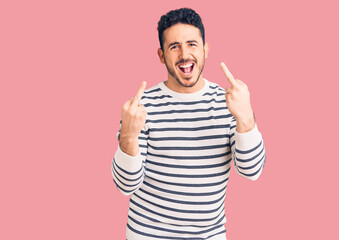Naklejka premium Young hispanic man wearing casual clothes showing middle finger doing fuck you bad expression, provocation and rude attitude. screaming excited