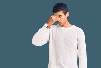 Young african amercian man wearing casual clothes tired rubbing nose and eyes feeling fatigue and...