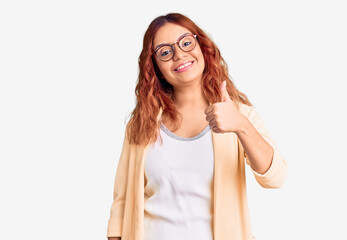 Fototapeta premium Young latin woman wearing business clothes doing happy thumbs up gesture with hand. approving expression looking at the camera showing success.