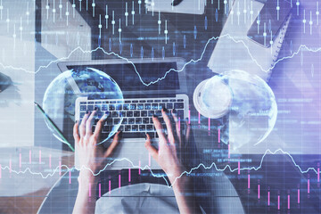 Double exposure of woman hands working on computer and forex chart hologram drawing. Top View. Financial analysis concept.