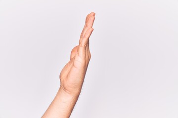 Naklejka premium Close up of hand of young caucasian man over isolated background showing side of stretched hand, pushing and doing stop gesture