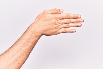 Close up of hand of young caucasian man over isolated background stretching and reaching with open hand for handshake, showing back of the hand