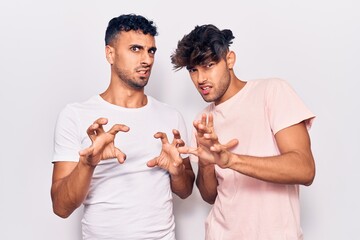 Young gay couple wearing casual clothes disgusted expression, displeased and fearful doing disgust...