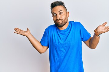 Handsome man with beard wearing casual clothes clueless and confused with open arms, no idea and...