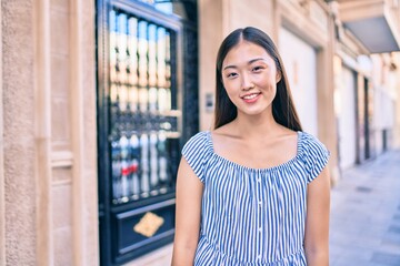 Young chinese woman smiling happy walking at street of city.