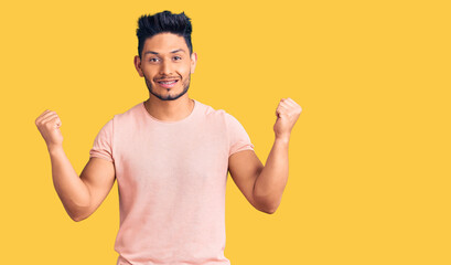 Handsome latin american young man wearing casual clothes screaming proud, celebrating victory and success very excited with raised arms