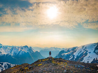 Norway - Man standing on mountain top under the sun between fjords 