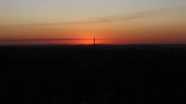 Timelapse de p&ocirc;r do sol alaranjado em &aacute;rea rural na cidade de Maring&aacute;, no estado do Paran&aacute;, Brasil