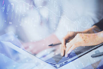 Double exposure of woman hands typing on computer and forex chart hologram drawing. Stock market invest concept.