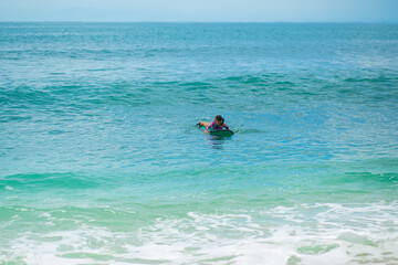 Sexy slim girl riding on surf board in the ocean. Healthy active lifestyle in summer vocation.