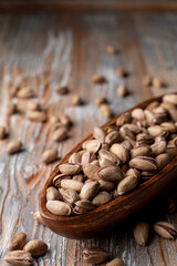 Sunflower seeds in a wooden bowl on a light rustic wooden table, close up, selective focus, catalogue photo