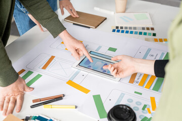 Hands of young contemporary software designers pointing at tablet display