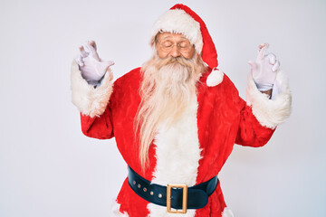 Old senior man with grey hair and long beard wearing santa claus costume with suspenders gesturing finger crossed smiling with hope and eyes closed. luck and superstitious concept.