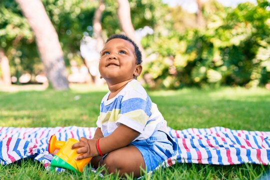 Adorable african american toddler smiling happy playing with toy at the park.