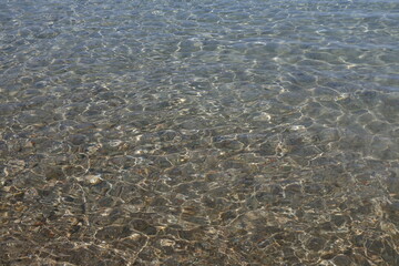 acqua cristallina con fondale di piccoli sassi