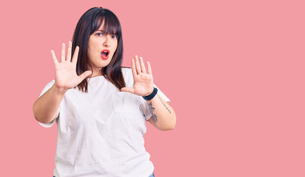 Young plus size woman wearing casual clothes doing stop gesture with hands palms, angry and frustration expression