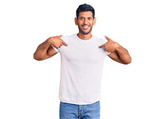 Young latin man wearing casual clothes looking confident with smile on face, pointing oneself with...