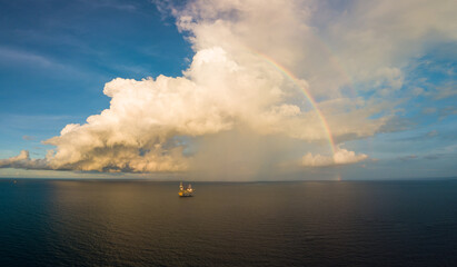 Naklejka na ściany i meble Aerial panorama view from a drone of an offshore jack up rig with beautiful sky and rainbow at the offshore location
