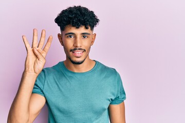 Young arab handsome man wearing casual clothes showing and pointing up with fingers number four while smiling confident and happy.