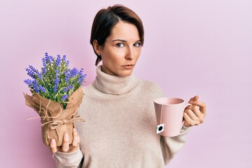 Young brunette woman with short hair drinking a cup of infused lavender clueless and confused...
