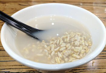 sweet fermented grains with black spoon in the bowl for eating