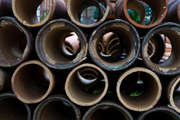 Concrete sewer pipes stacked in rows on the street.