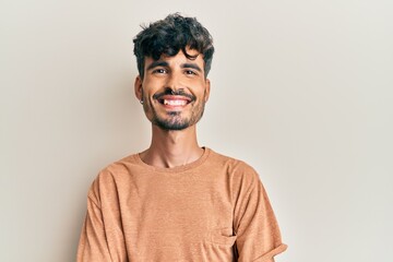 Young hispanic man wearing casual clothes happy face smiling with crossed arms looking at the camera. positive person.