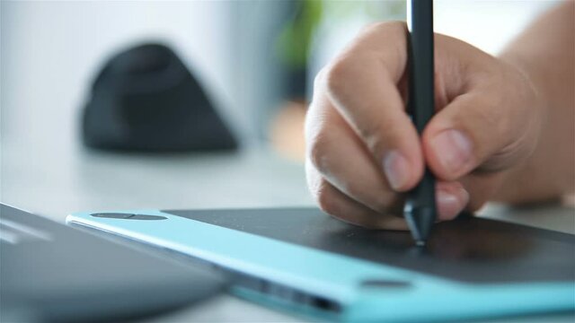 Designer hands using a graphics tablet and laptop at home. Creative Design And Working Concept