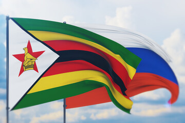 Waving Russian flag and flag of Zimbabwe. Closeup view, 3D illustration.