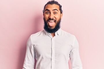 Young arab man wearing casual clothes sticking tongue out happy with funny expression. emotion concept.