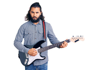 Fototapeta na wymiar Young arab man playing electric guitar thinking attitude and sober expression looking self confident