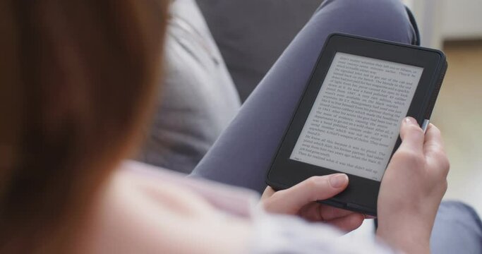 A woman reading an e-book at home.