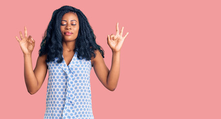 Beautiful african american woman wearing casual summer shirt relax and smiling with eyes closed doing meditation gesture with fingers. yoga concept.