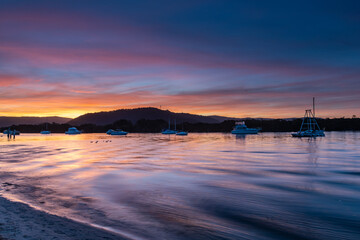 Naklejka premium Sunset at the waterfront with high cloud and boats