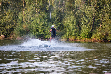 Wakeboarding on the sea on summer day in life jacket. Soft focus. Action blur.