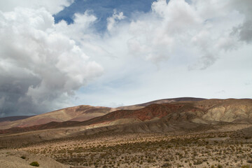 Fototapeta na wymiar Desert landscape. Majestic view of the arid valley and mountains under a beautiful cloudy sky.