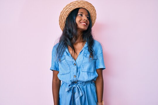 Young indian girl wearing summer hat looking to side, relax profile pose with natural face and confident smile.