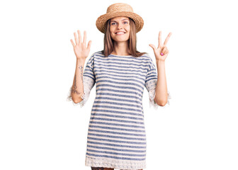 Obraz na płótnie Canvas Beautiful caucasian woman wearing summer hat showing and pointing up with fingers number eight while smiling confident and happy.