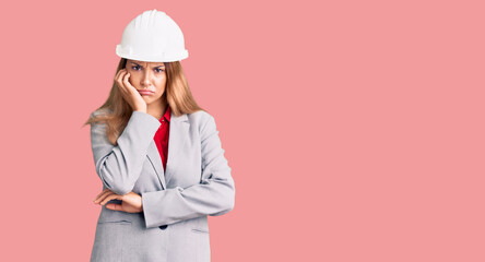 Beautiful young woman wearing architect hardhat thinking looking tired and bored with depression problems with crossed arms.