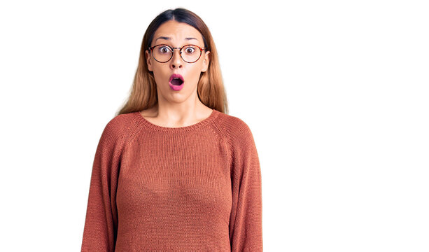Beautiful young woman wearing casual clothes and glasses afraid and shocked with surprise expression, fear and excited face.