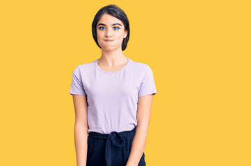 Brunette teenager girl wearing casual clothes puffing cheeks with funny face. mouth inflated with...