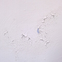 Spoiled fresh white paint close-up. Cracked new paint on a white wall