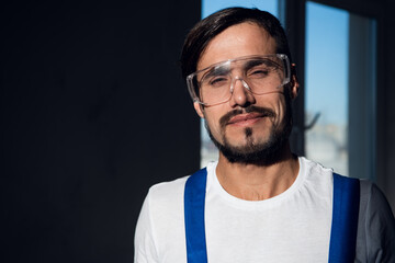 Male engineer wearing blue overalls and goggles on his head