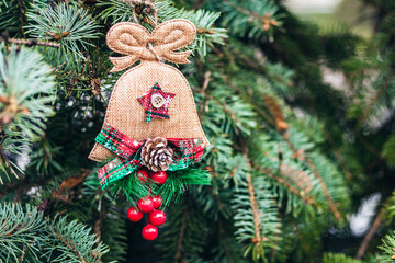 green Christmas tree branch with a homemade burlap toy, New Year background with copy space for text.