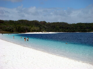 Fototapeta na wymiar clear lake blue white sand trees beach