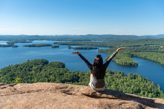 Woman enjoying the view of Squam lake from West Rattlesnake Mountain New Hampshire